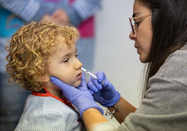 Vacunación intranasal frente a la gripe de un niño.